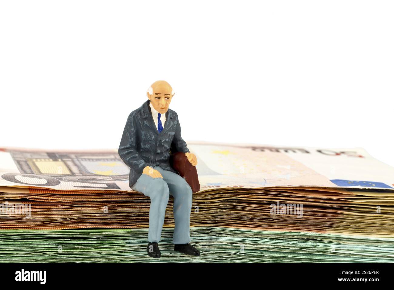 Foto simbolica per il pensionamento e la sicurezza vecchiaia, figura di un vecchio seduto su una pila di banconote Austria Foto Stock