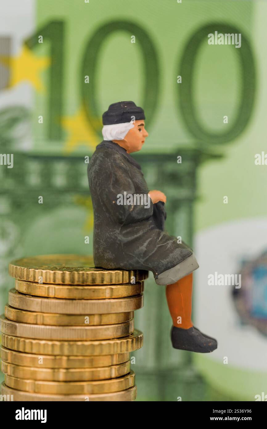 Pensionato seduto su un mucchio di soldi, foto simbolica per la pensione, vecchiaia, sicurezza per la vecchiaia Foto Stock