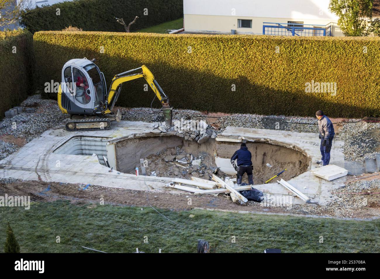 Una piscina è smantellata da un escavatore in un cantiere privato in Austria Foto Stock