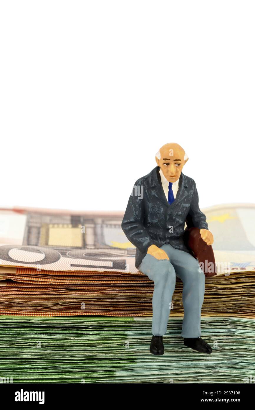 Foto simbolica per il pensionamento e la sicurezza vecchiaia, figura di un vecchio seduto su una pila di banconote Austria Foto Stock