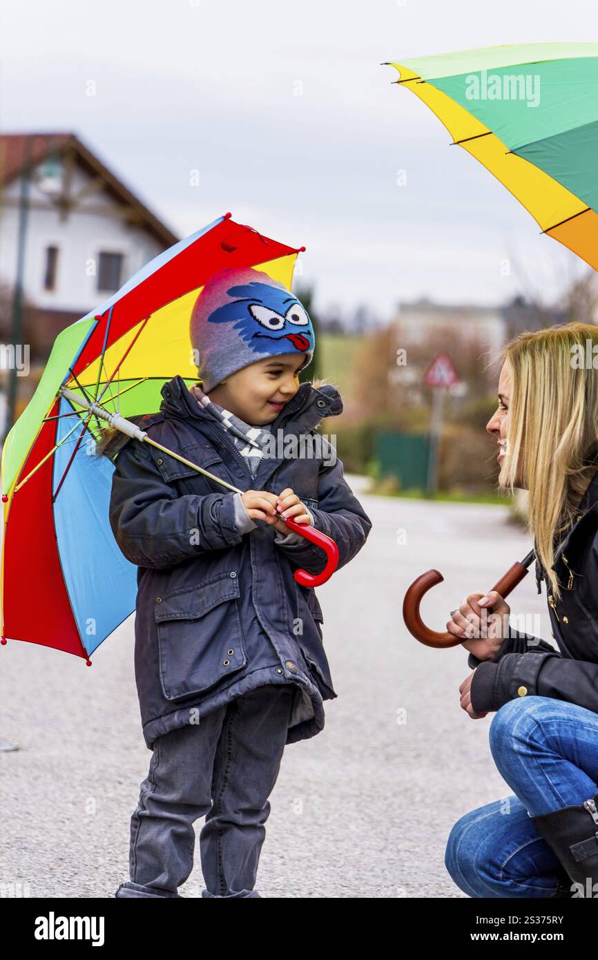 Madre e bambino con ombrello, simbolo di solidarietà, aiuto, pacchetto di aiuti, ombrello di salvataggio Austria Foto Stock