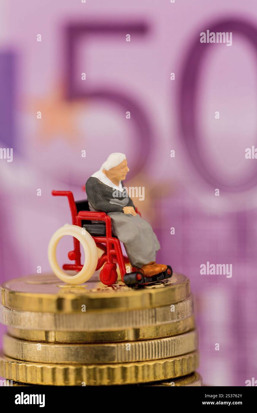 Donna in sedia a rotelle su mucchio di soldi, foto simbolica per disabilità, indennità di assistenza e costi in assistenza sanitaria Austria Foto Stock