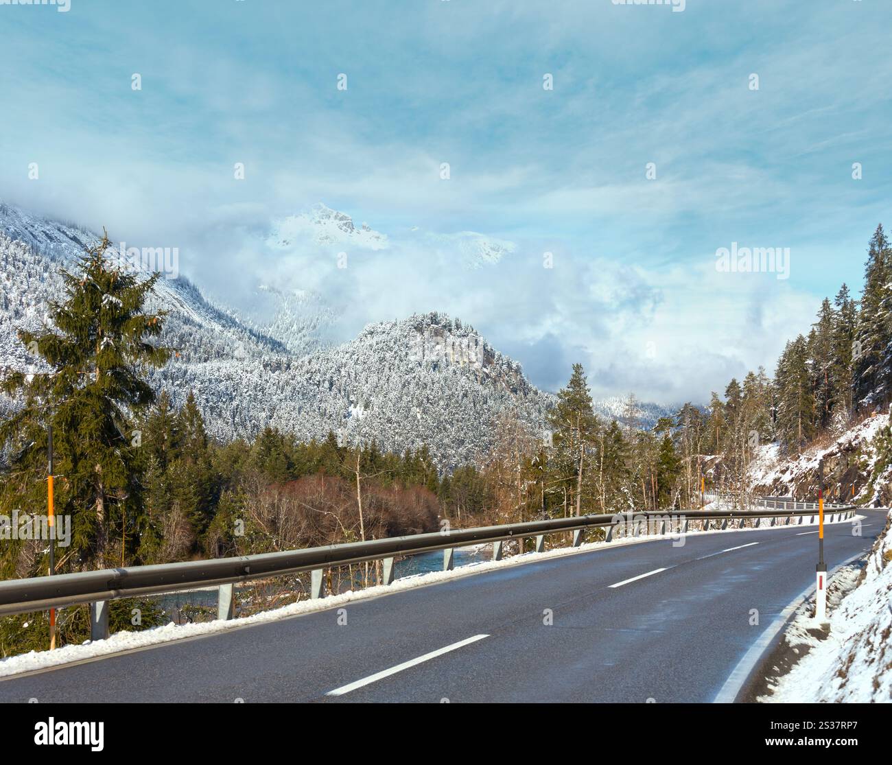 La strada lungo il fiume e coperto di neve e piste di montagna (Austria, Tirolo). Foto Stock