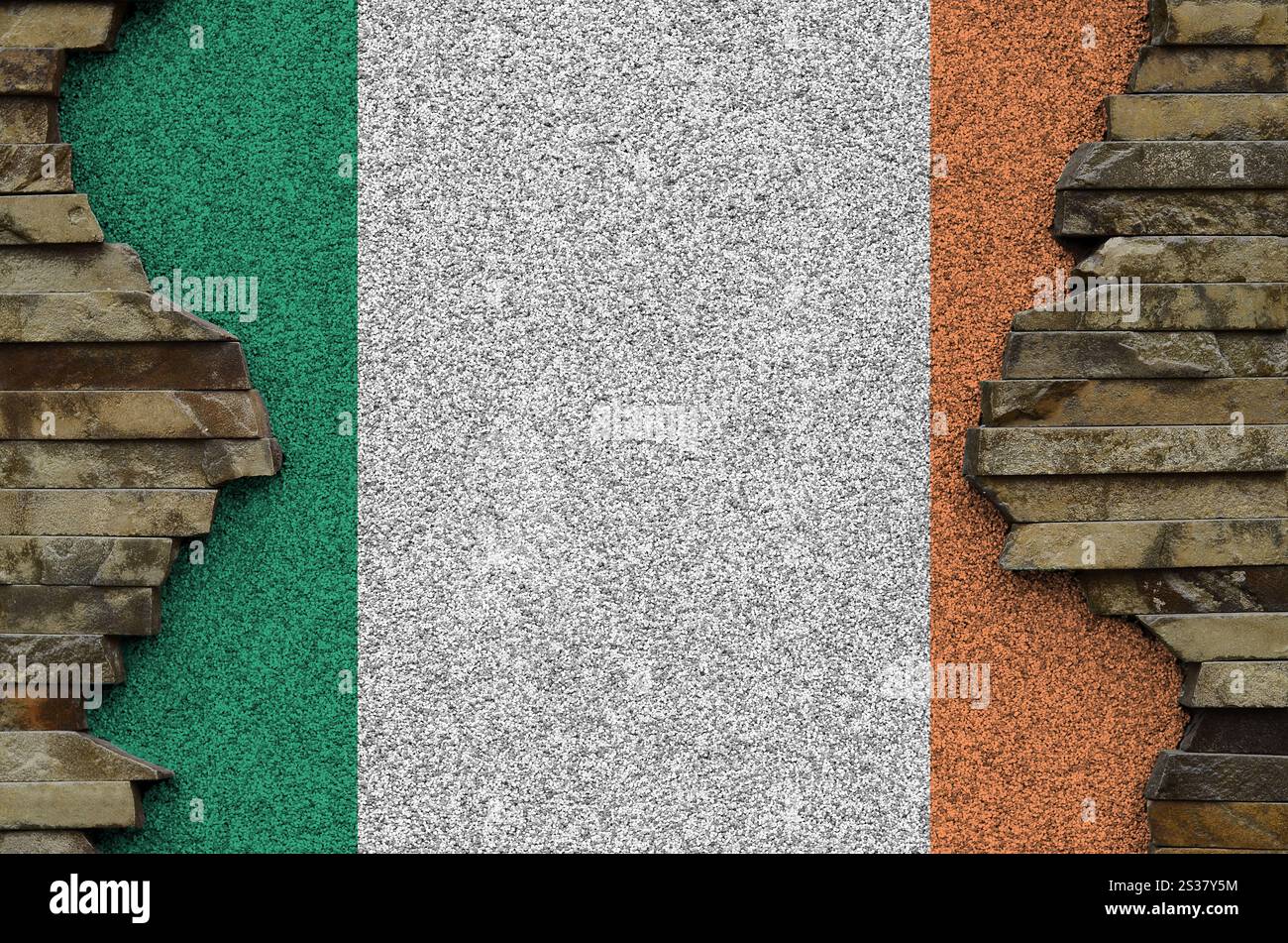 Bandiera dell'Irlanda raffigurata in colori pittoreschi su un vecchio muro di pietra da vicino. Striscione testurizzato su sfondo di pareti rocciose. Bandiera dell'Irlanda raffigurata con colori a colori su Foto Stock