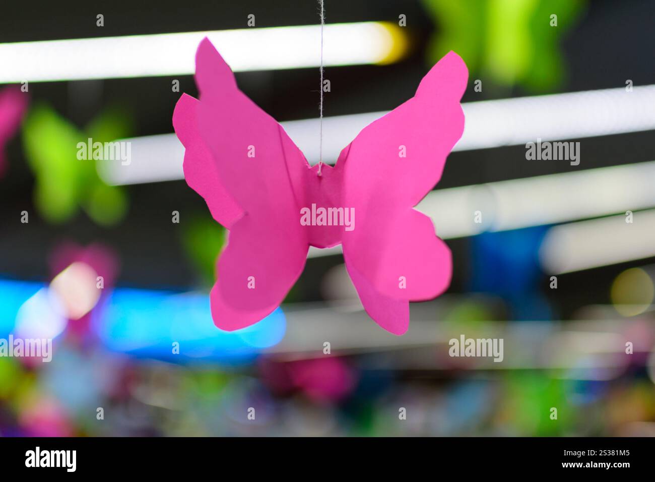 Farfalla rosa Origami sullo sfondo del bokeh al neon. Foto digitale. Farfalla rosa Origami sullo sfondo del bokeh al neon Foto Stock