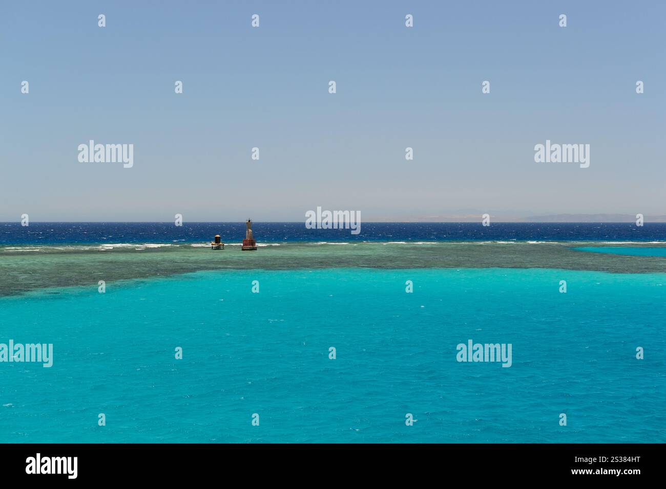 Faro all'orizzonte della foto del mare blu. Faro all'orizzonte del mare blu Foto Stock