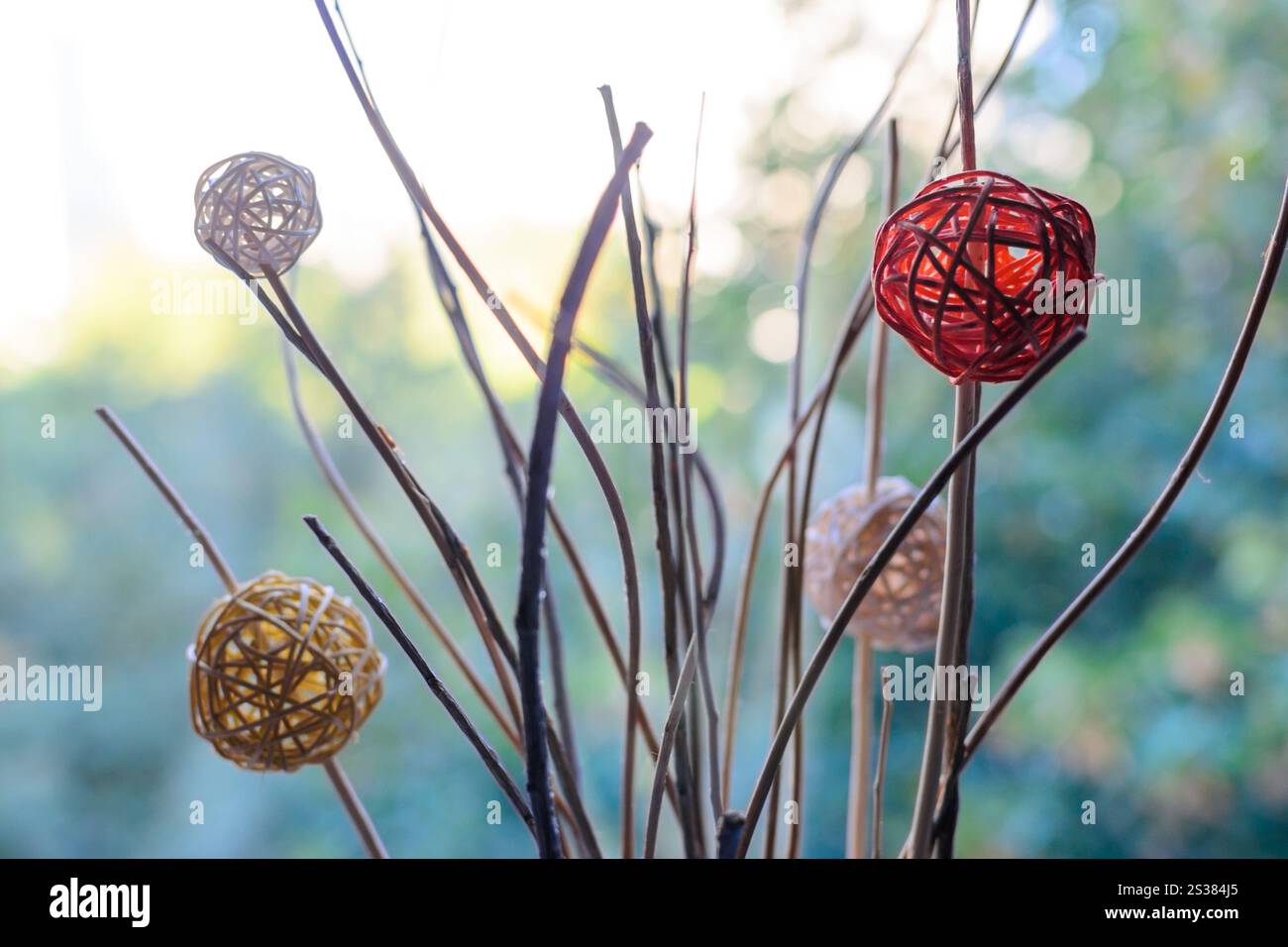 Decorazioni moderne con palle intrecciate su rami secchi sfondo bokeh sfocato. Foto decorativa. Decorazioni moderne con palle intrecciate su rami secchi sfondo bokeh sfocato Foto Stock