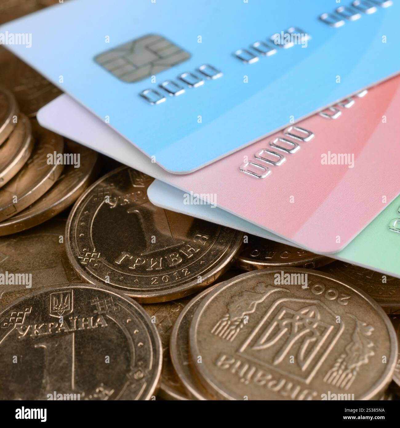 Le monete ucraine e le carte di credito colorate chiudono. Valuta dell'Ucraina. Bilanciamento del denaro e concetto di online banking. Wireless banking globale Foto Stock