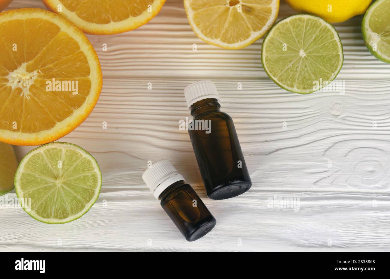 Bottiglia di essenza di olio con estratti di agrumi. Messa a fuoco selettiva. Spa Day, concetto di bottiglia di olio freschezza con limone lime ed estratto di arancia. Essenza d'olio Foto Stock