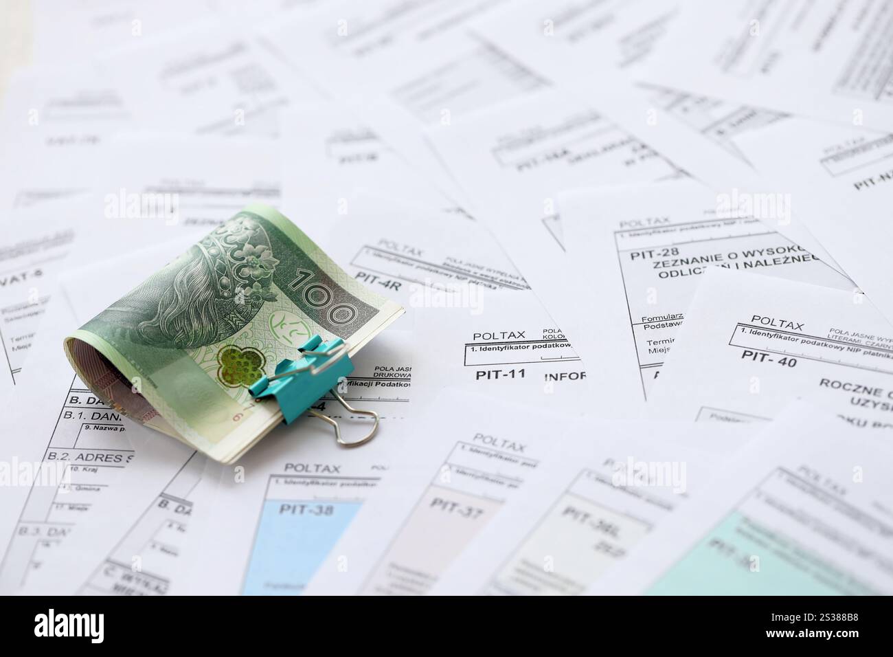 Soldi zloty polacchi PLN su una grande quantità di PIT polacco, CIT e moduli fiscali IVA da vicino. La contabilità, la burocrazia e la routine dei contribuenti in Polonia. Polacco Foto Stock