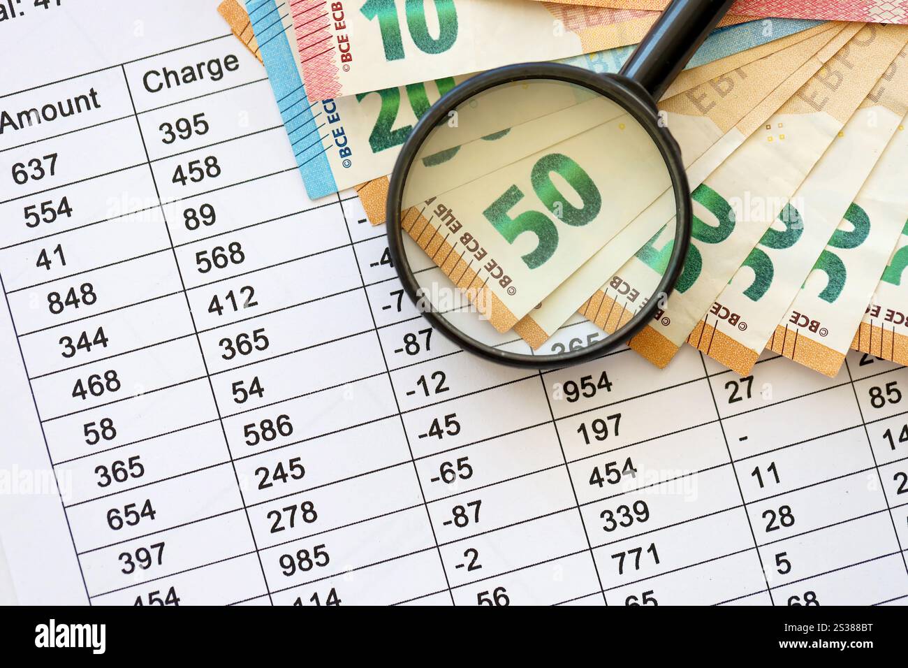 Concetto di business e risparmio con molte banconote in euro e lente d'ingrandimento in primo piano. Concetto di business e risparmio con molte bollette in euro e. Foto Stock