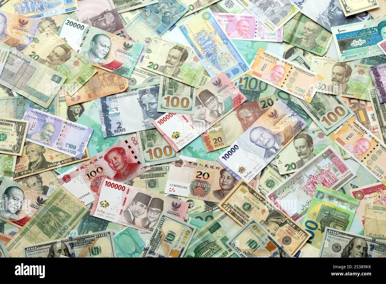 Molte banconote di valuta diversa. Sfondo di grandi quantità di banconote casuali primo piano. Molte banconote di valuta diversa. Sfondo di Foto Stock