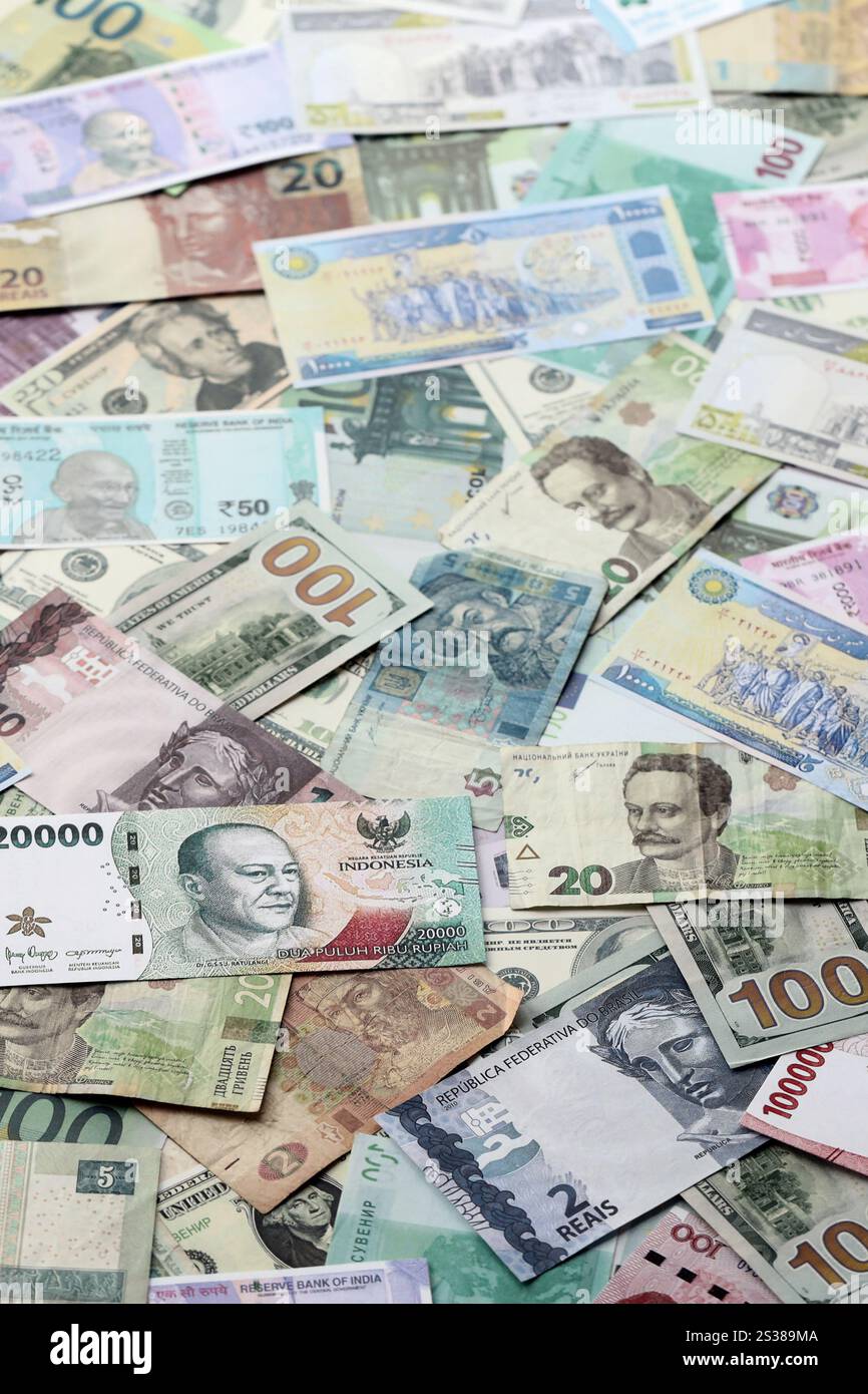 Molte banconote di valuta diversa. Sfondo di grandi quantità di banconote casuali primo piano. Molte banconote di valuta diversa. Sfondo di Foto Stock