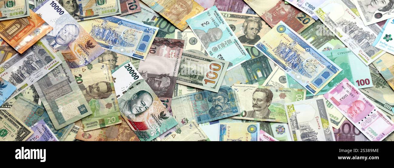 Molte banconote di valuta diversa. Sfondo di grandi quantità di banconote casuali primo piano. Molte banconote di valuta diversa. Sfondo di Foto Stock