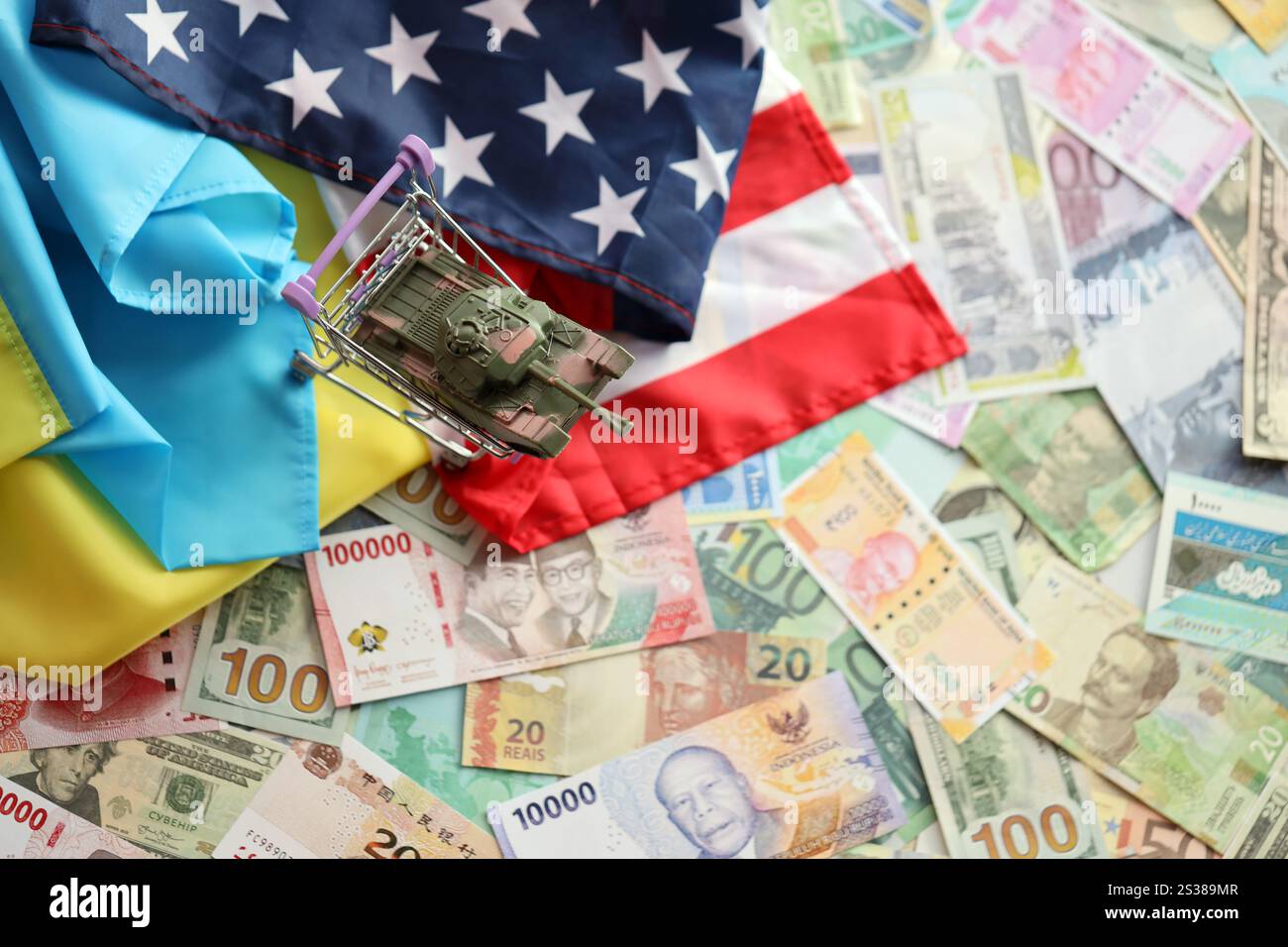 Serbatoio giocattolo sulla bandiera degli Stati Uniti e bandiera ucraina su molte banconote di valuta diversa. Contesto di finanziamento di guerra e sostegno militare tra Stati Uniti Foto Stock