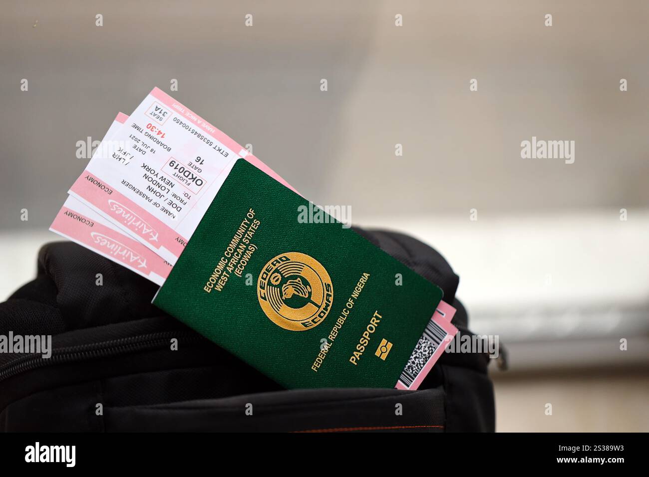 Passaporto nigeriano verde con biglietti aerei sullo zaino turistico da vicino. Concetto di turismo e viaggio. Passaporto nigeriano verde con biglietti aerei Foto Stock