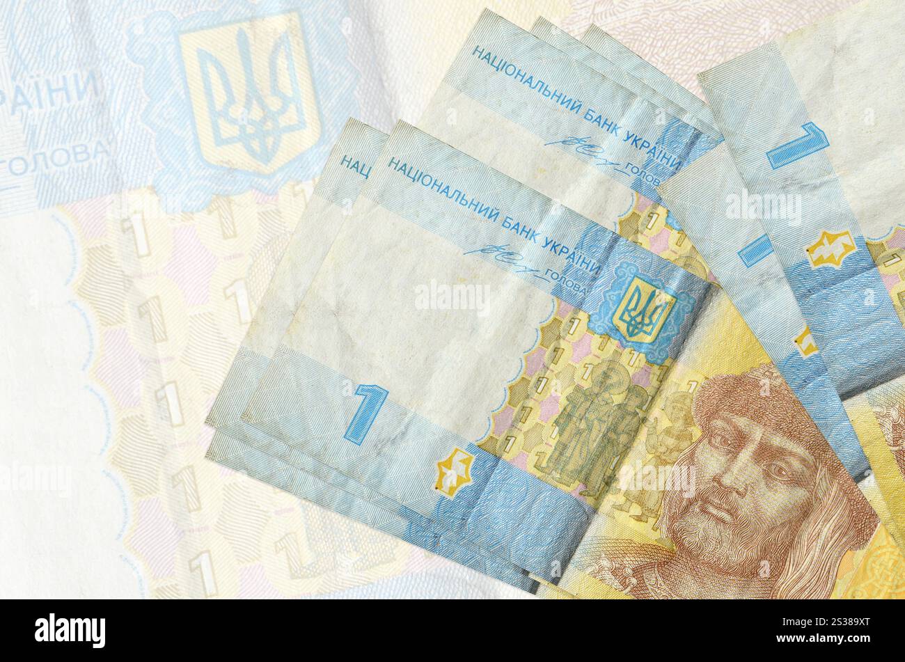 1 le banconote ucraine in grivna si trovano in una pila sullo sfondo di una grande banconota semi-trasparente. Presentazione astratta della moneta nazionale. Concetto di business. Foto Stock