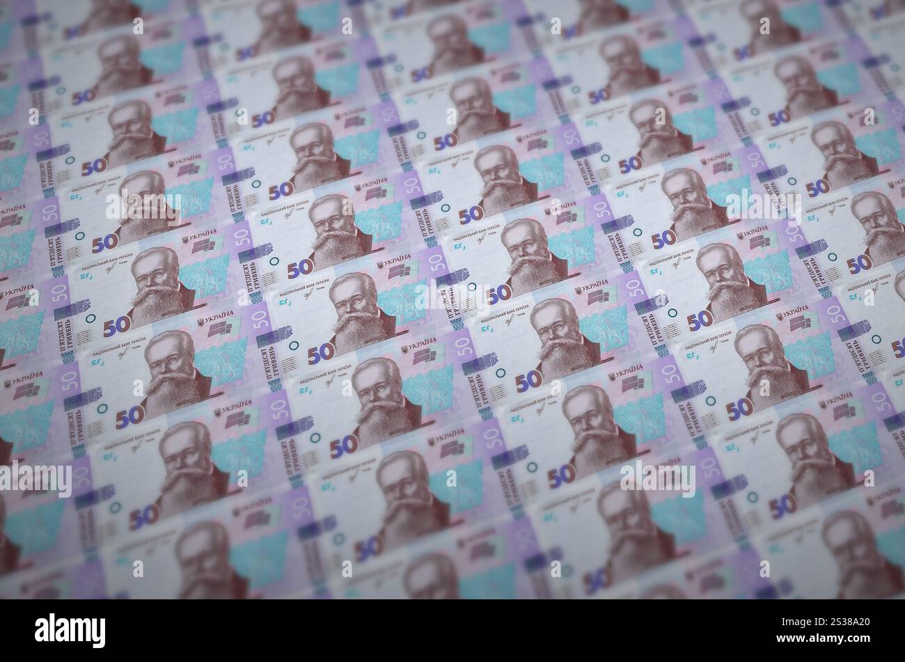 50 banconote ucraine di hryvnias stampate in un trasportatore di produzione di denaro illegale. Collage di molte banconote false. Concetto di lavoro di massa dei contraffattori. 50 Foto Stock