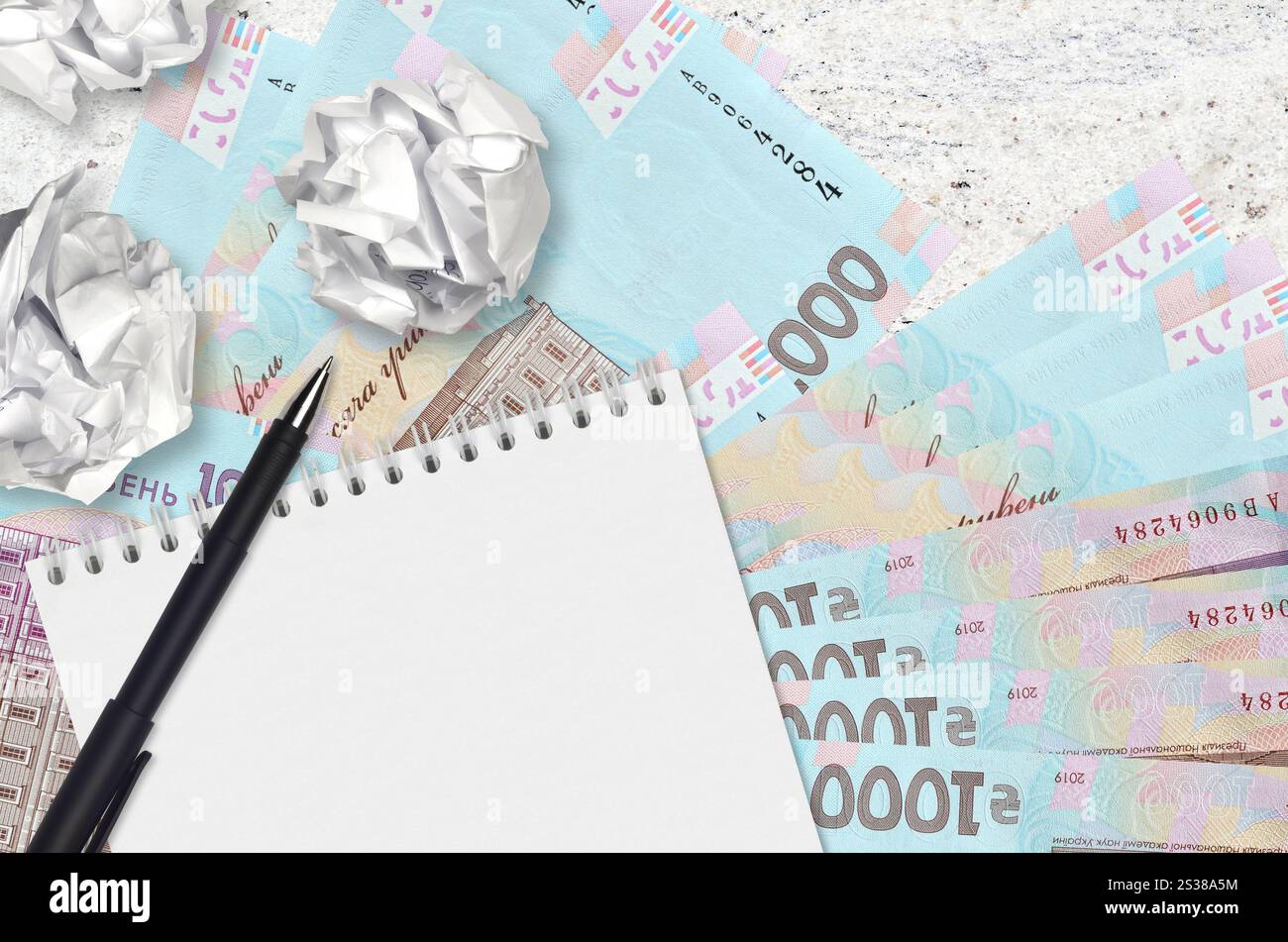 1000 hryvnias ucraine banconote e palle di carta stropicciata con blocco note. Idee cattive o meno di concetto di ispirazione. Alla ricerca di idee per l'investimento. Foto Stock