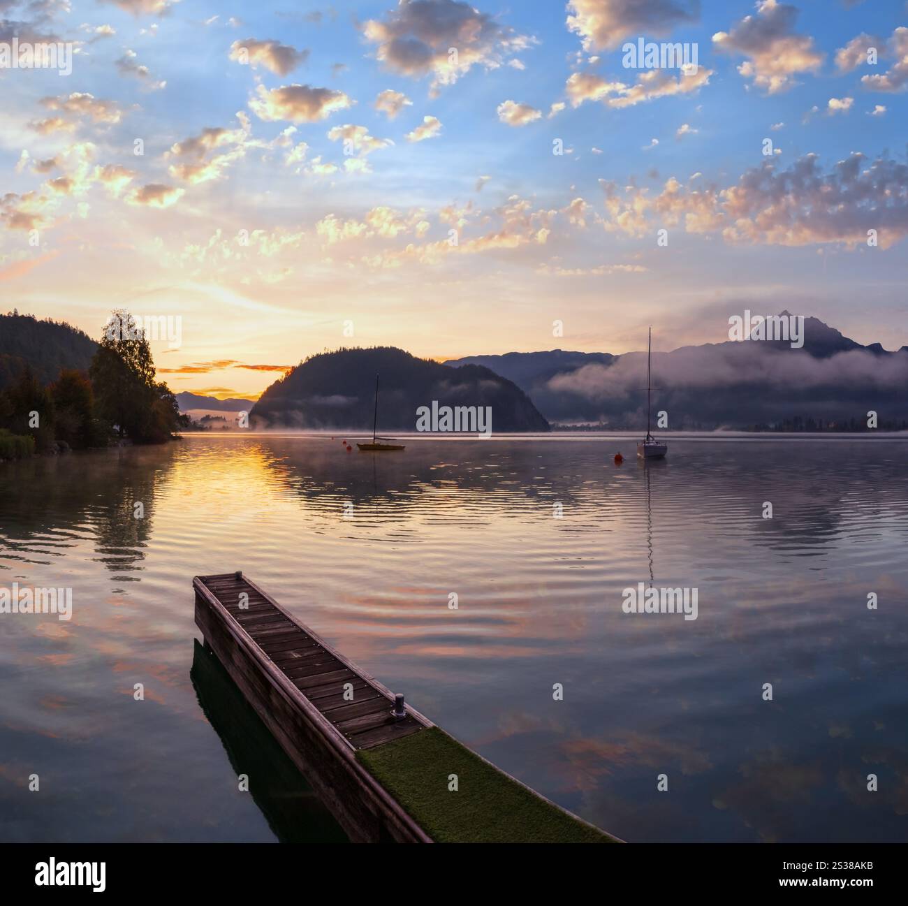 Tranquillo autunno Alpi montagna lago. Alba Wolfgangsee lago vista, St. Wolfgang im Salzkammergut, alta Austria. Foto Stock