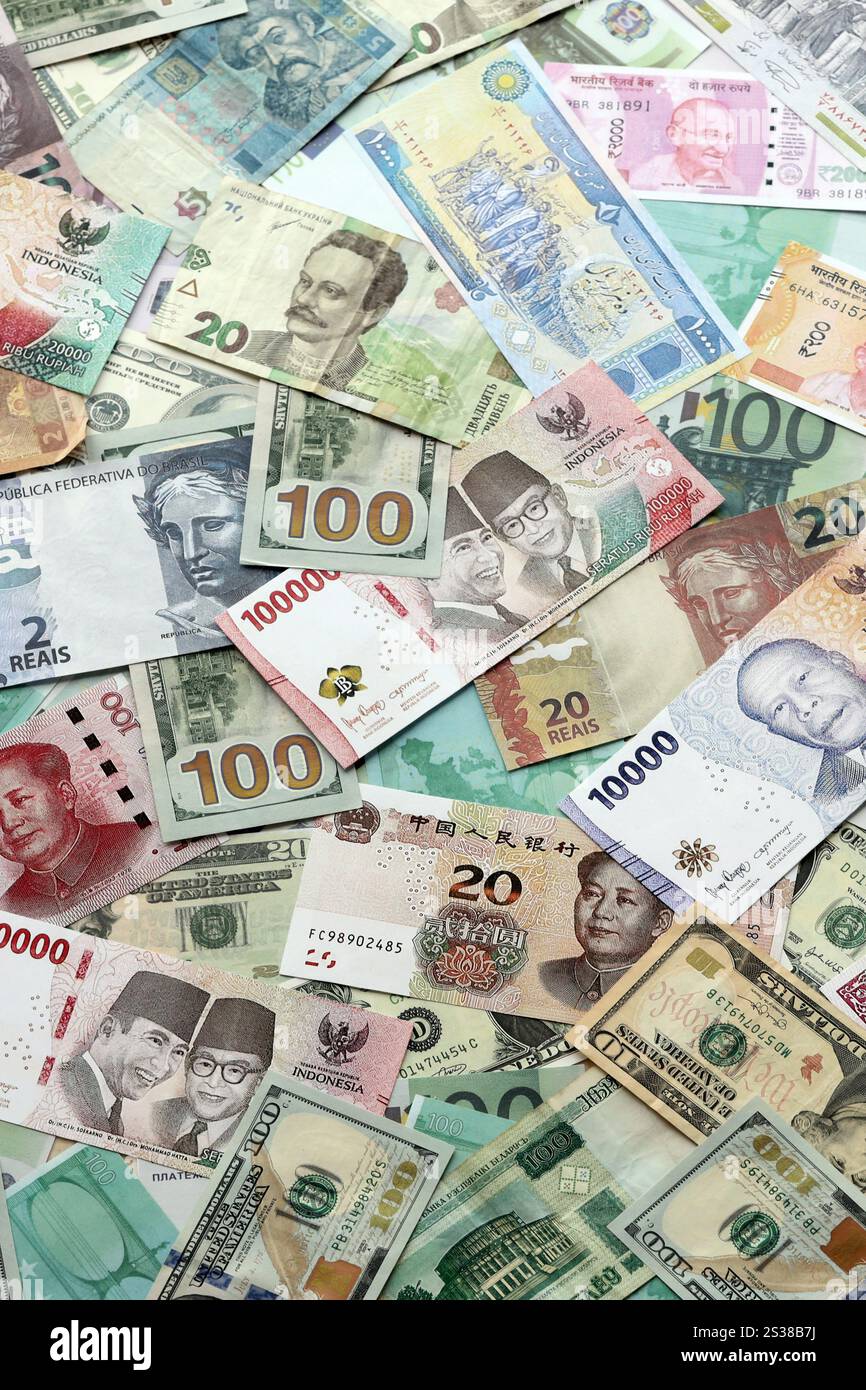 Molte banconote di valuta diversa. Sfondo di grandi quantità di banconote casuali primo piano. Molte banconote di valuta diversa. Sfondo di Foto Stock
