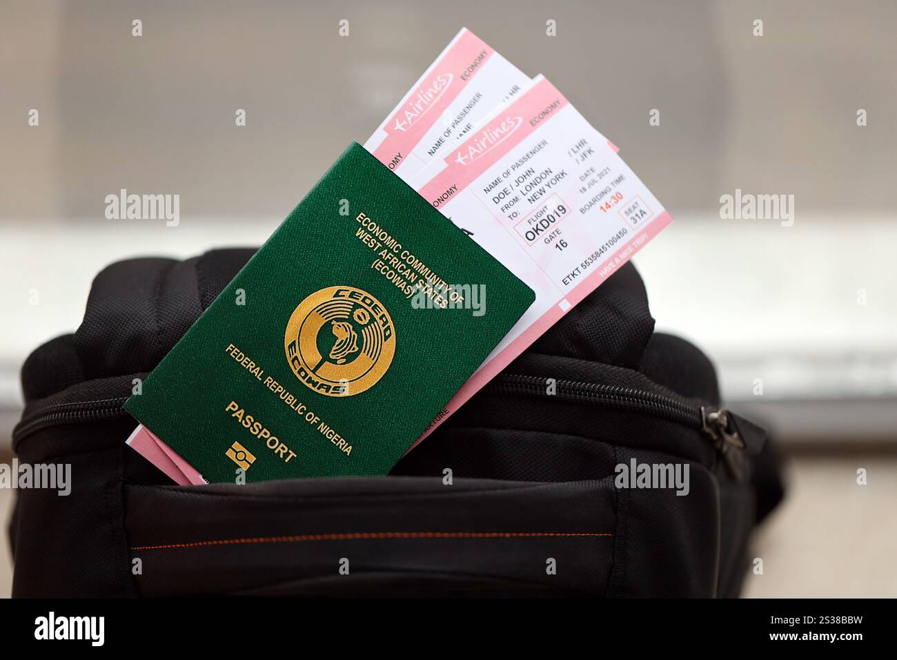 Passaporto nigeriano verde con biglietti aerei sullo zaino turistico da vicino. Concetto di turismo e viaggio. Passaporto nigeriano verde con biglietti aerei Foto Stock