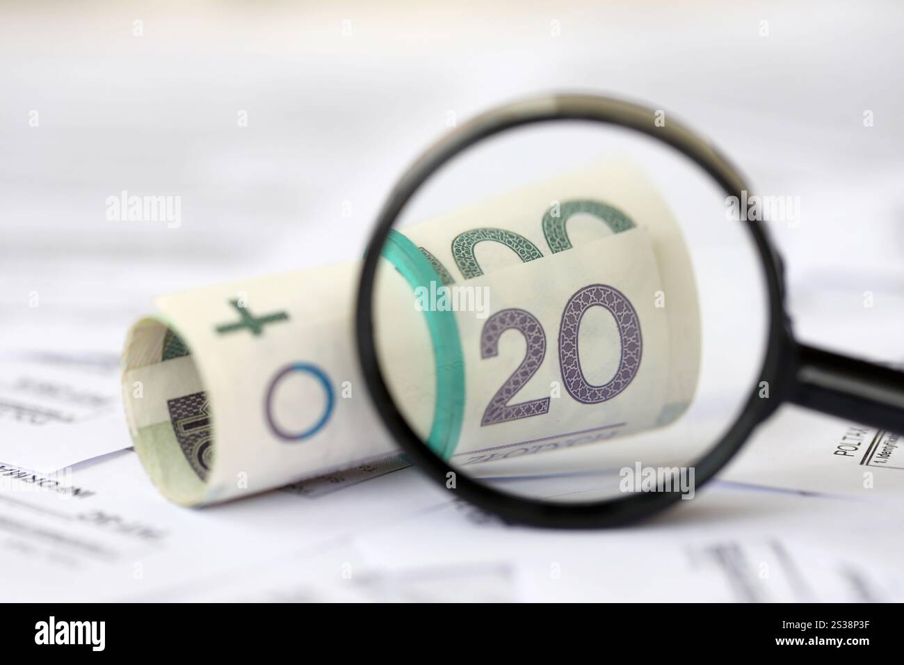 Soldi zloty polacchi e lente d'ingrandimento su una grande quantità di moduli fiscali polacchi da vicino. La contabilità, la burocrazia e la routine dei contribuenti in Polonia. Polacco Foto Stock