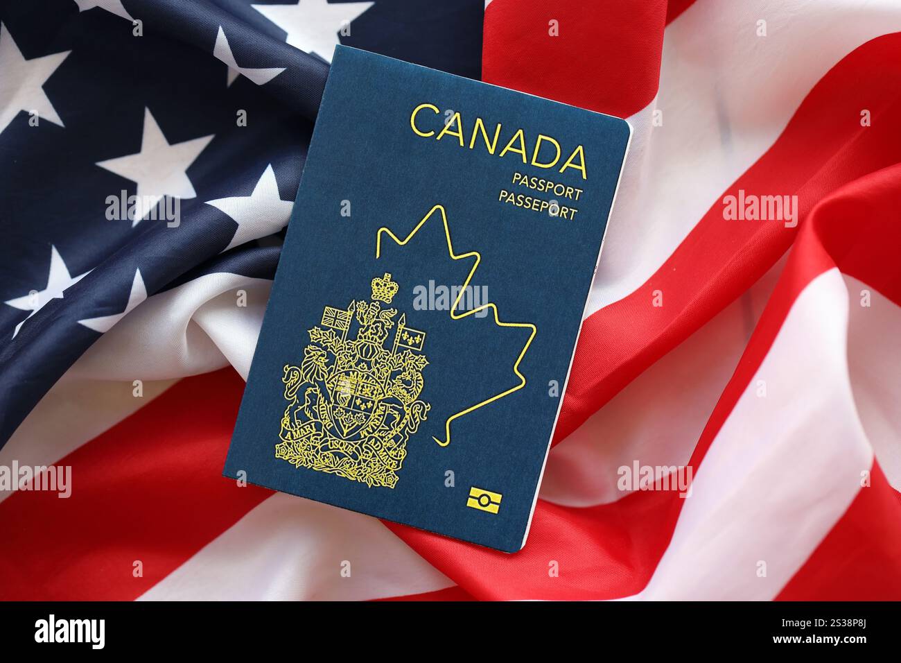 Passaporto canadese sullo sfondo della bandiera nazionale degli Stati Uniti primo piano. Concetto di turismo e diplomazia. Passaporto canadese sulla bandiera degli Stati Uniti Foto Stock