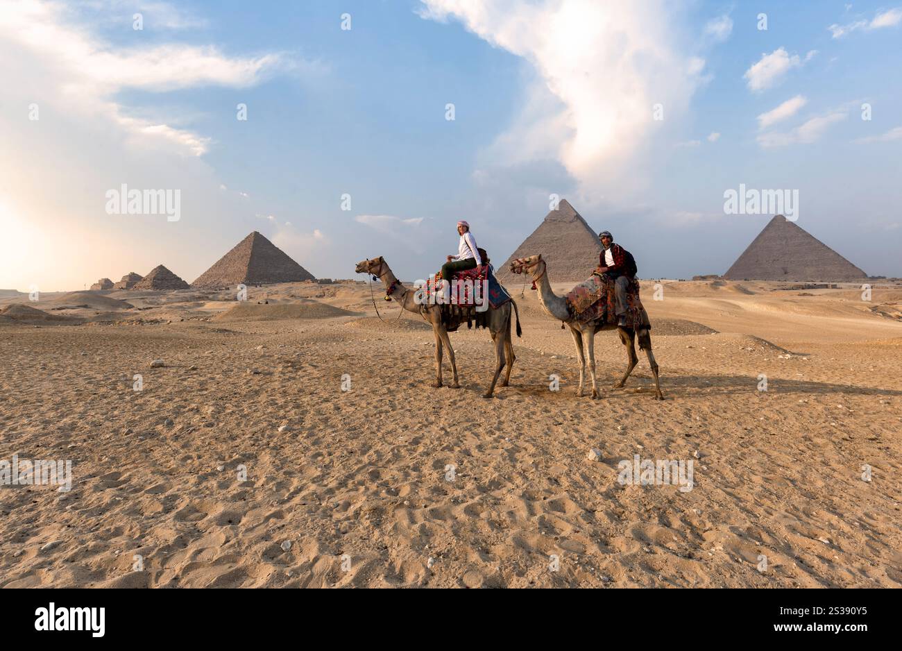 Grandi Piramidi di Giza - coppia a cavallo di cammelli nel deserto Foto Stock