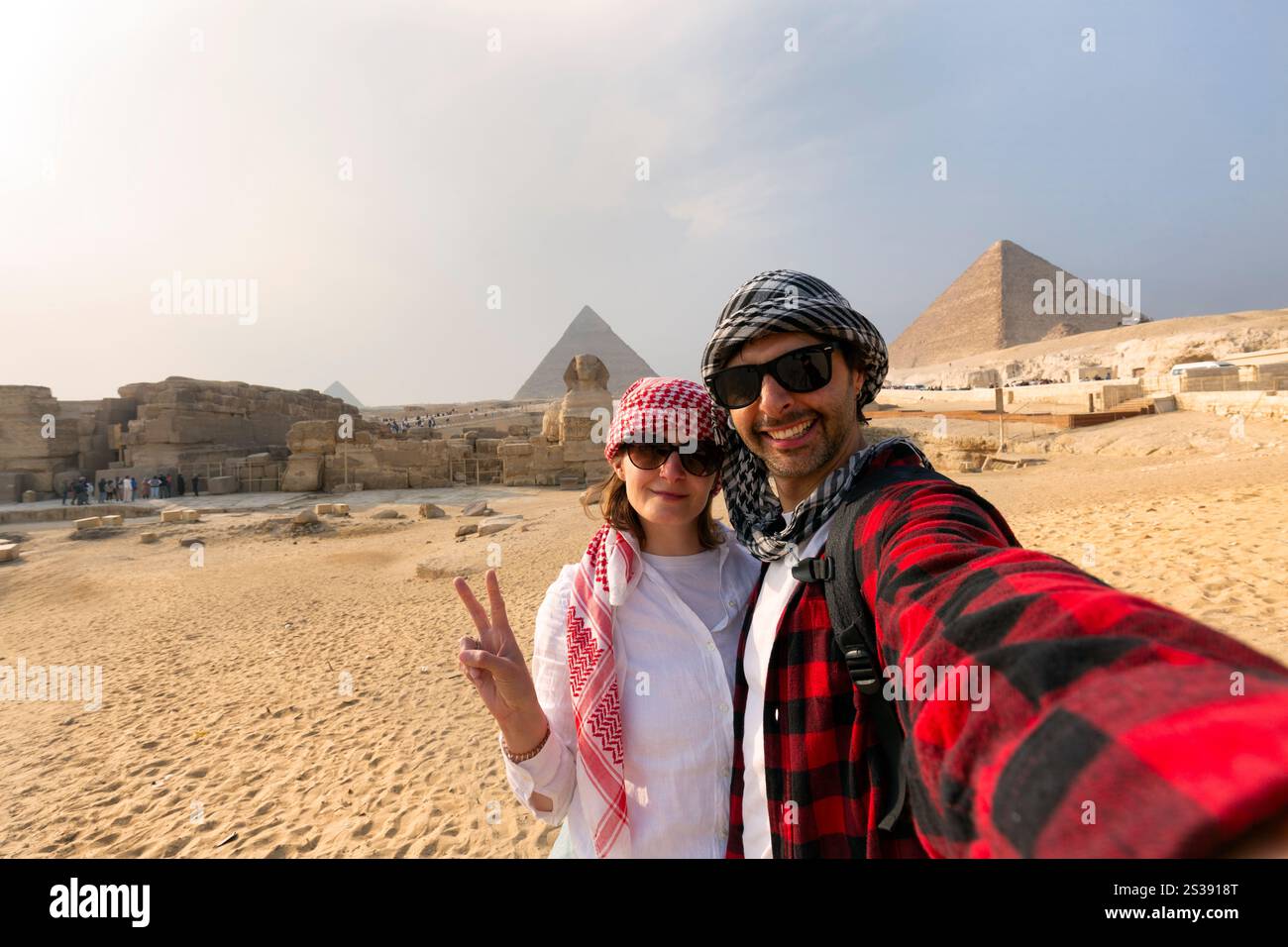 Giovane coppia che scatta foto di selfie di fronte alle grandi Piramidi di Giza, Egitto Foto Stock