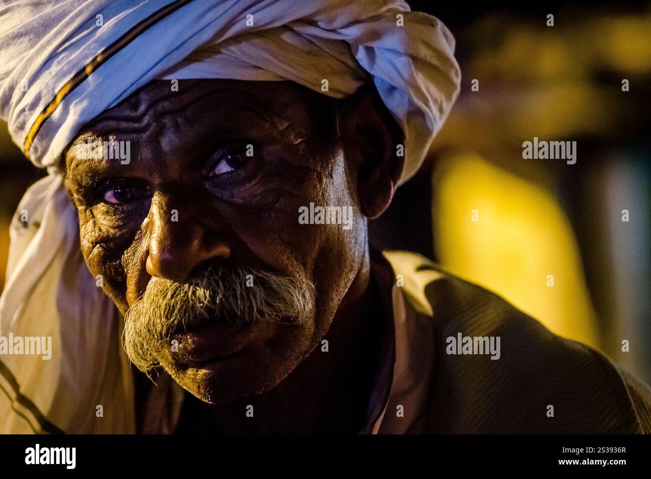 Ritratto di un uomo anziano con baffi in abito tradizionale al crepuscolo in un ambiente rurale Foto Stock