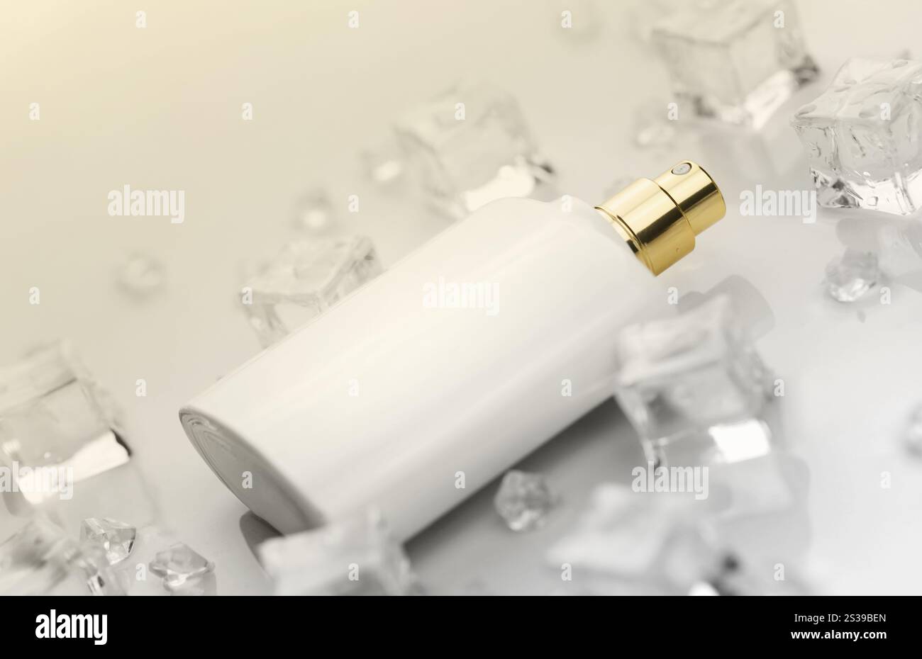 Bottiglia bianca di profumo femminile, fotografia obiettiva di bottiglia di profumo in cubetti di ghiaccio e acqua su tavola bianca. Vista dall'alto. Foto prodotto mockup, Foto Stock