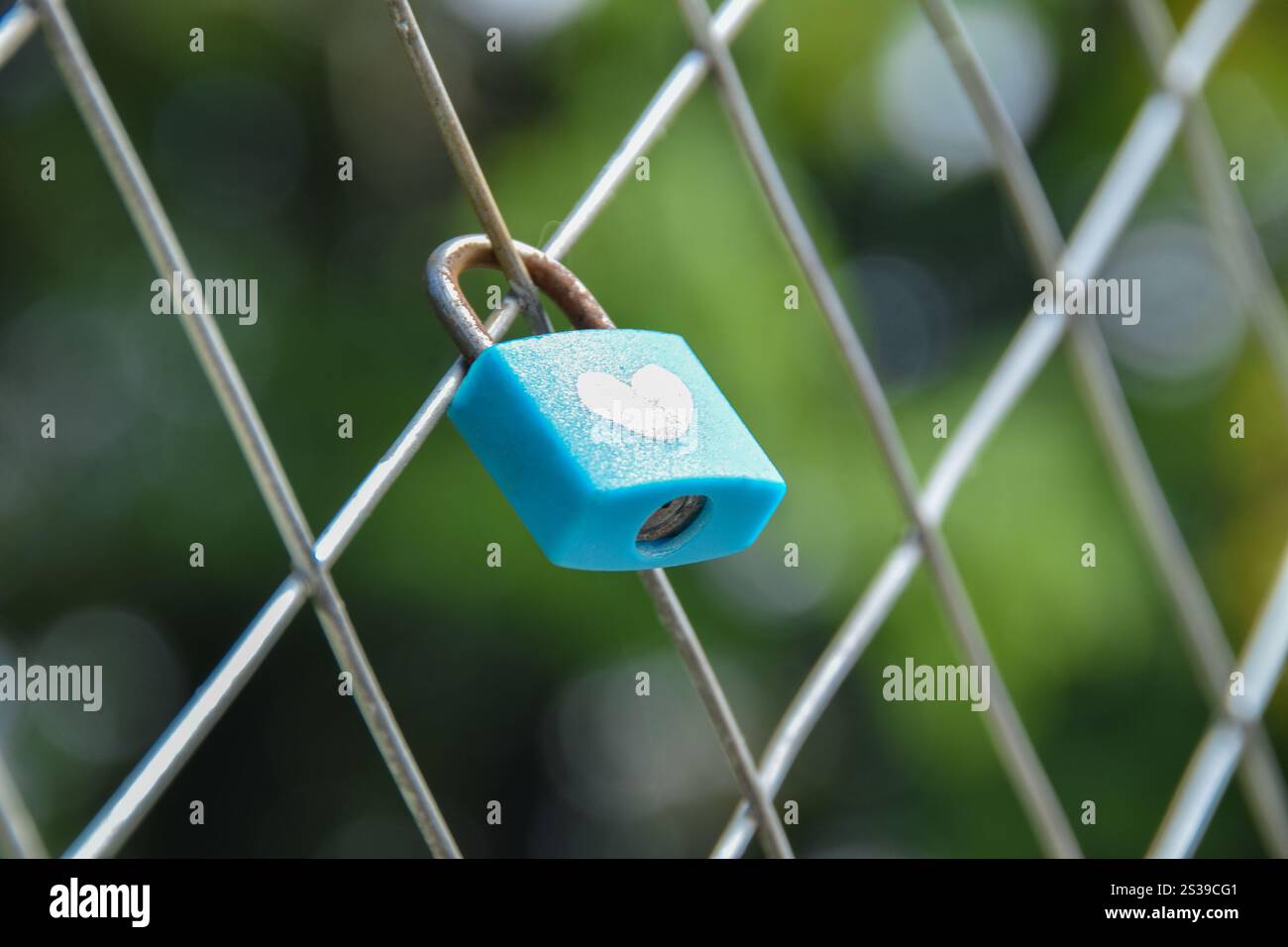 Primo piano Blue Love Padlock appeso alla recinzione. La chiave con lucchetto e simbolo d'amore a forma di cuore. Un posto dove le persone esprimono amore. Foto Stock