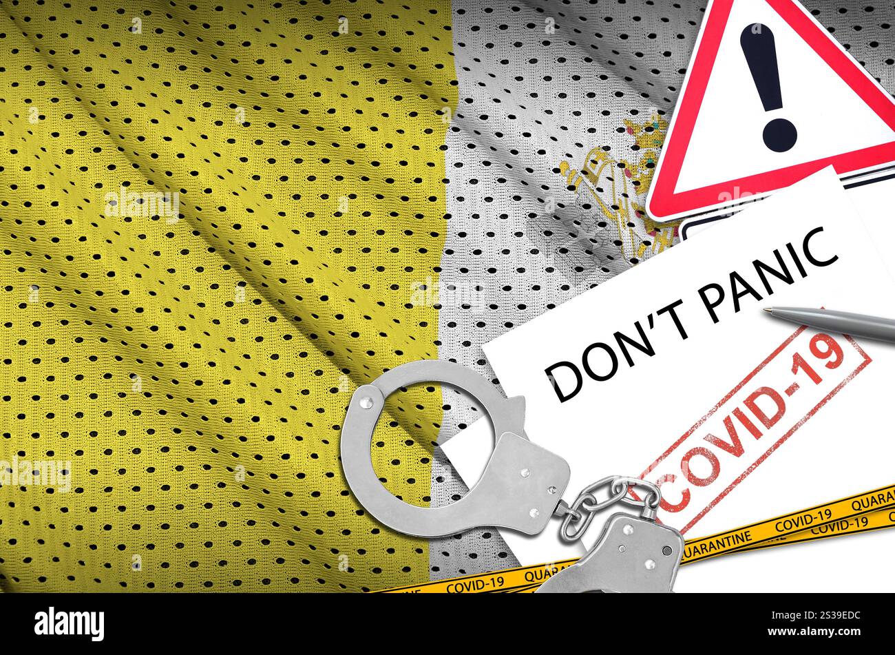 La bandiera dello Stato della città del Vaticano e le manette della polizia con iscrizione non si panico su carta bianca. Coronavirus o pandemia 2019-nCoV virus concetto. Vaticano Foto Stock