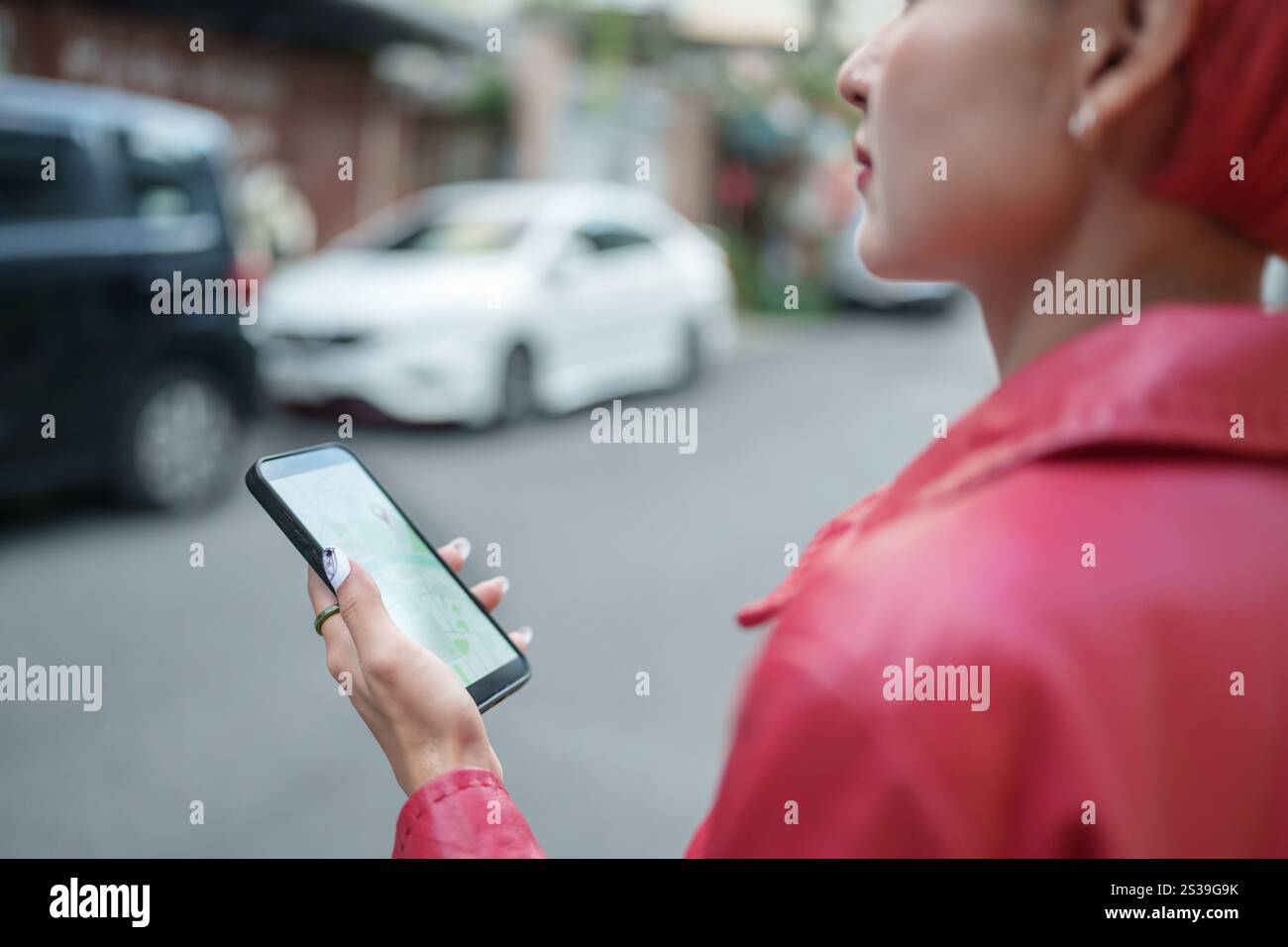 Viaggiatore Gen z ragazza moda in pelle con punk donna asiatica turista in città strada ricerca posizione nella mappa applicazione smartphone online uso Foto Stock