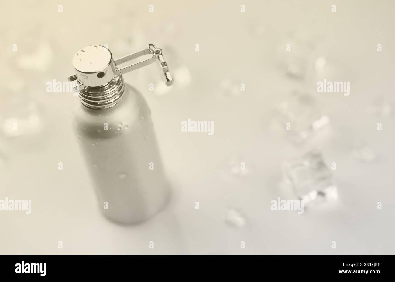 Bottiglia argentata di profumo femminile, Fotografia obiettivo di bottiglia di profumo metallico in cubetti di ghiaccio e acqua su tavola bianca. Vista dall'alto. Prodotto mockup Foto Stock