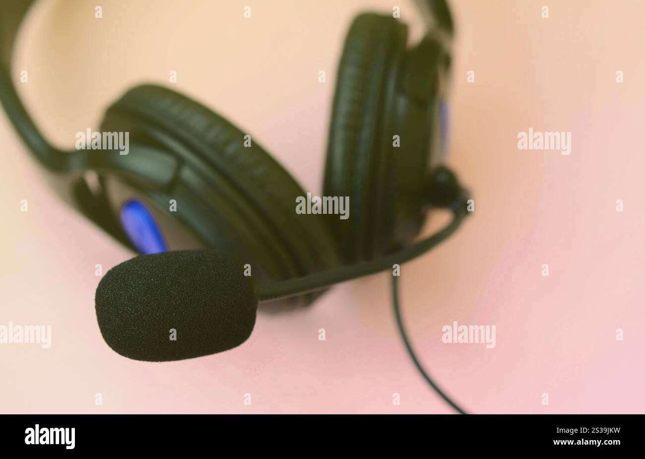 Le cuffie nere si trovano su un colorato sfondo rosa pastello. Concetto di ascolto musicale. Concetto di ascolto musicale. Le cuffie nere si trovano su sfondo rosa Foto Stock