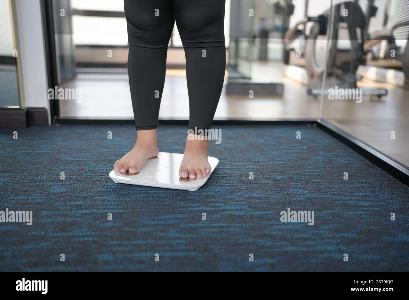 Dieta grassa e piedini graduati posizionati su bilance elettroniche per il controllo del peso. Strumento di misurazione in chilogrammi per il controllo della dieta Foto Stock