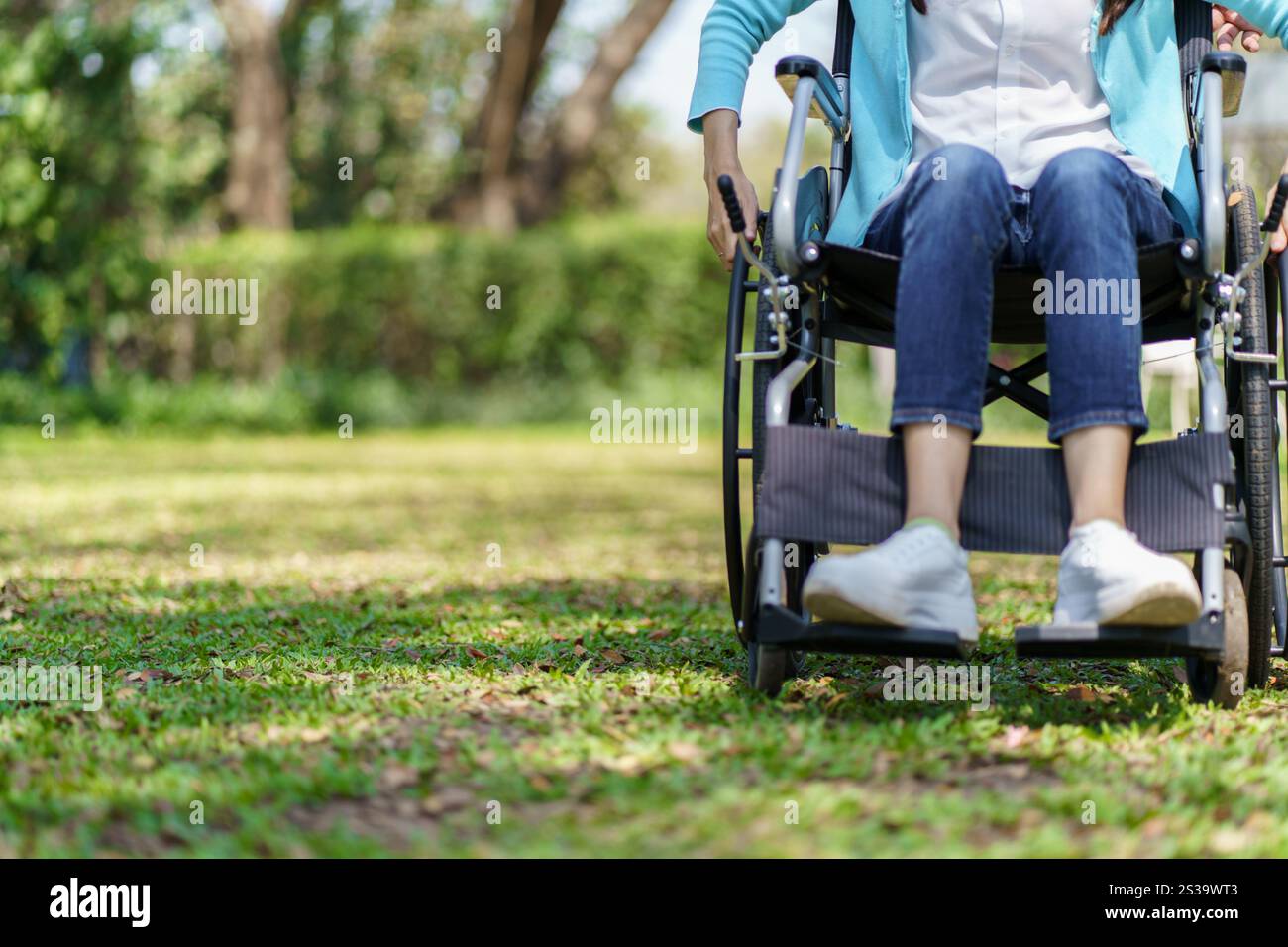 Giovane donna asiatica in sedia a rotelle con pensiero positivo Foto Stock