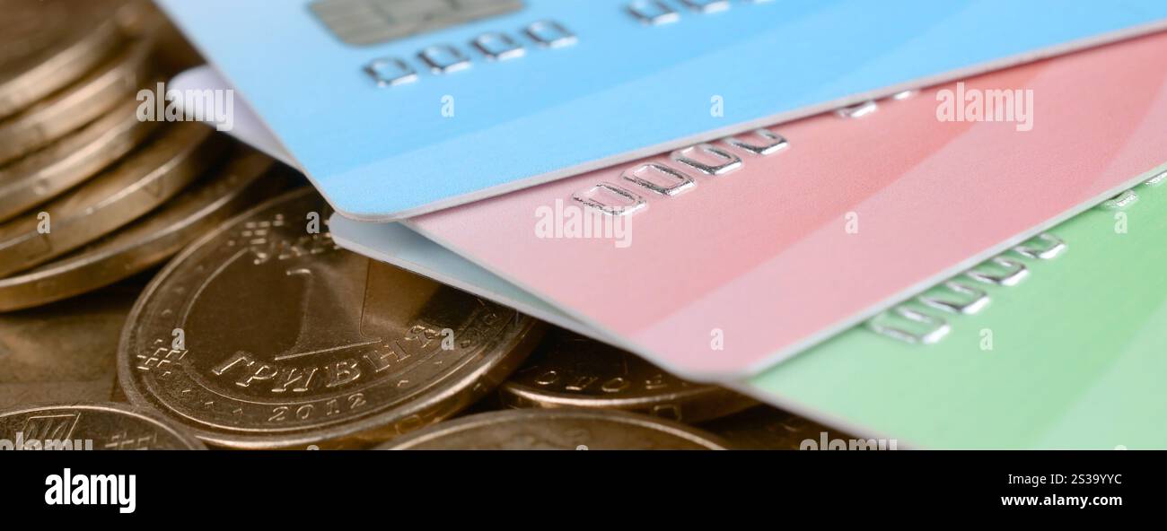 Le monete ucraine e le carte di credito colorate chiudono. Valuta dell'Ucraina. Bilanciamento del denaro e concetto di online banking. Wireless banking globale Foto Stock