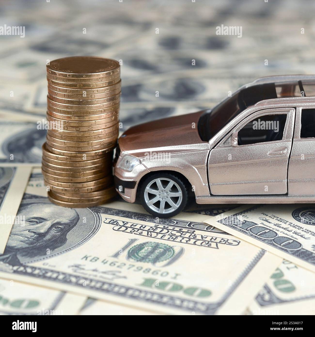 Auto giocattolo in un incidente su uno sfondo di banconote da 100 dollari e una pila di monete d'oro. Concetto di assicurazione auto. Incidente stradale, assicurazione auto Foto Stock