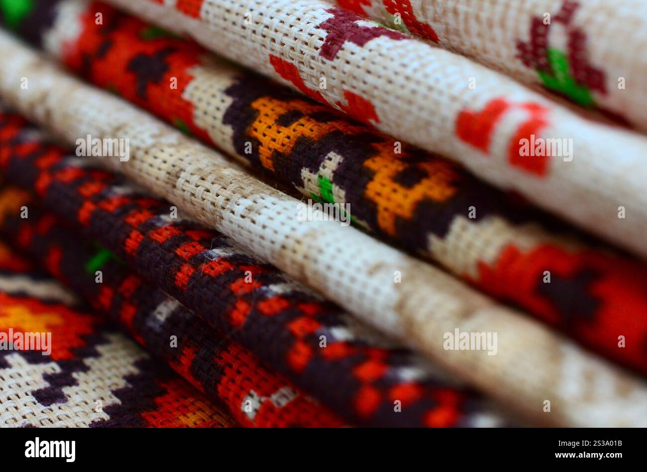 Pila di tradizionali disegni di arte popolare Ucraina lavorati a maglia su tessuto. Tela lavorata a maglia con design a pixel colorati. Una pila di tradizionali Foto Stock