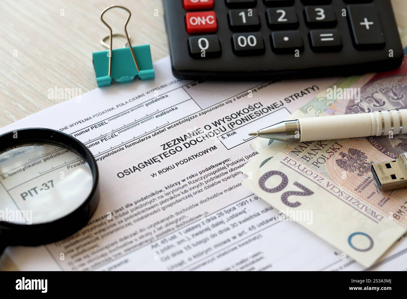 Dichiarazione dell'importo del reddito da lavoro o delle perdite subite, moduli fiscali PIT-37 sul contabile con pennarelli e banconote in denaro zloty polacco primo piano. Foto Stock