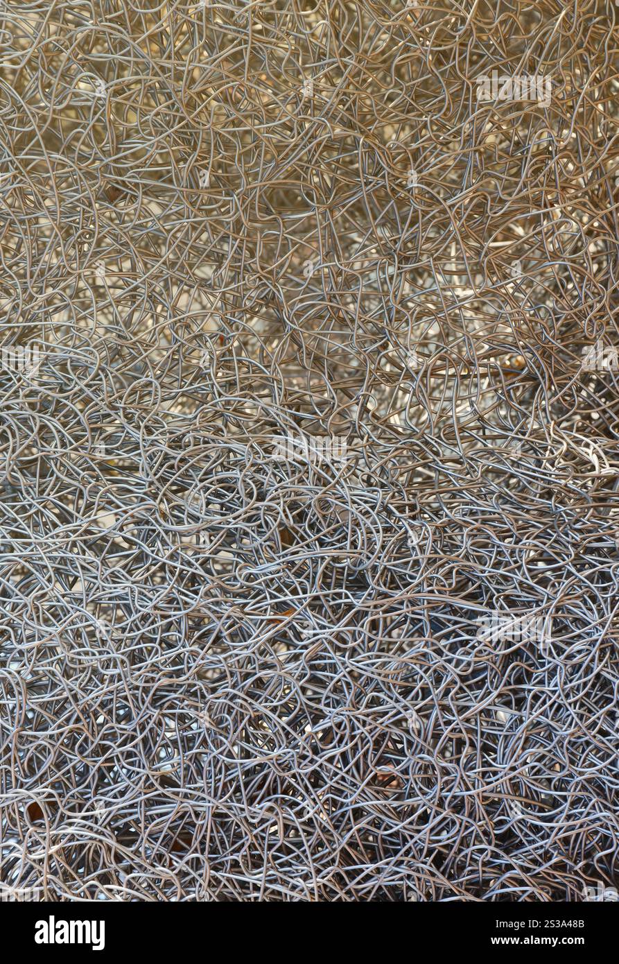 Sfondo con struttura metallica a schermo intero. Rottami di metalli non ferrosi. Concetto di riciclaggio per la progettazione. Sfondo della trama del filo metallico completo Foto Stock