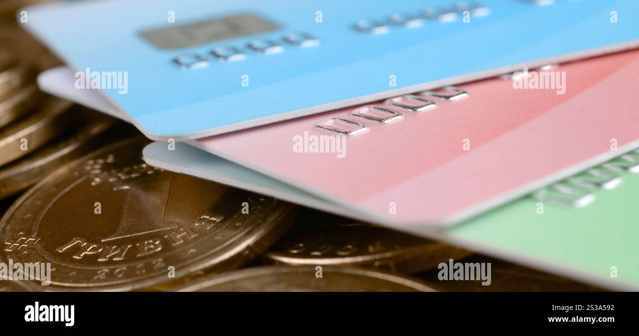 Le monete ucraine e le carte di credito colorate chiudono. Valuta dell'Ucraina. Bilanciamento del denaro e concetto di online banking. Wireless banking globale Foto Stock