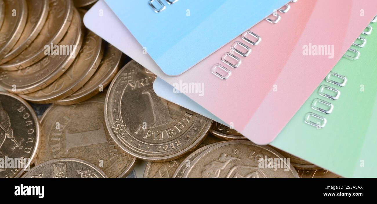 Le monete ucraine e le carte di credito colorate chiudono. Valuta dell'Ucraina. Bilanciamento del denaro e concetto di online banking. Wireless banking globale Foto Stock