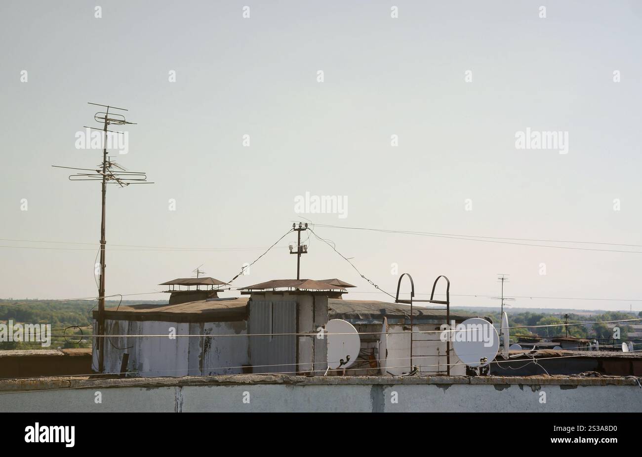 Parabole satellitari bianche con due convertitori montati sulla parete in cemento sul tetto dell'edificio residenziale. Pubblicità televisiva satellitare. Satellite bianco Foto Stock