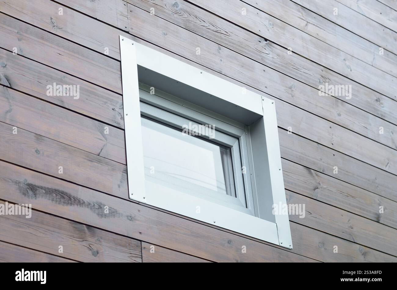 Finestra in PVC di plastica in una moderna facciata passiva in legno. Le finestre in PVC sono il numero uno all'interno dell'azienda per l'efficienza energetica. Nuova finestra in PVC in plastica Foto Stock