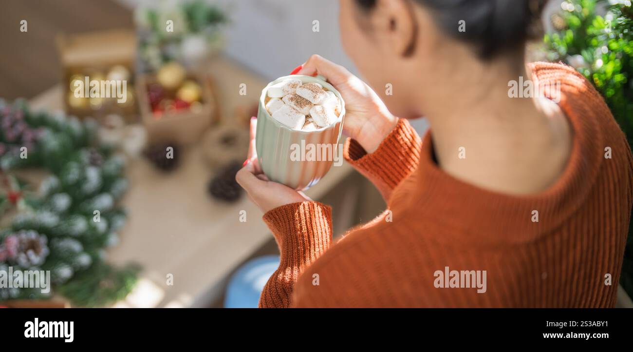 Donna che regge una tazza di cacao aromatico con marshmallow. La vigilia di Natale con una tazza di gustosa cioccolata calda atmosfera accogliente per le vacanze a casa. Foto Stock