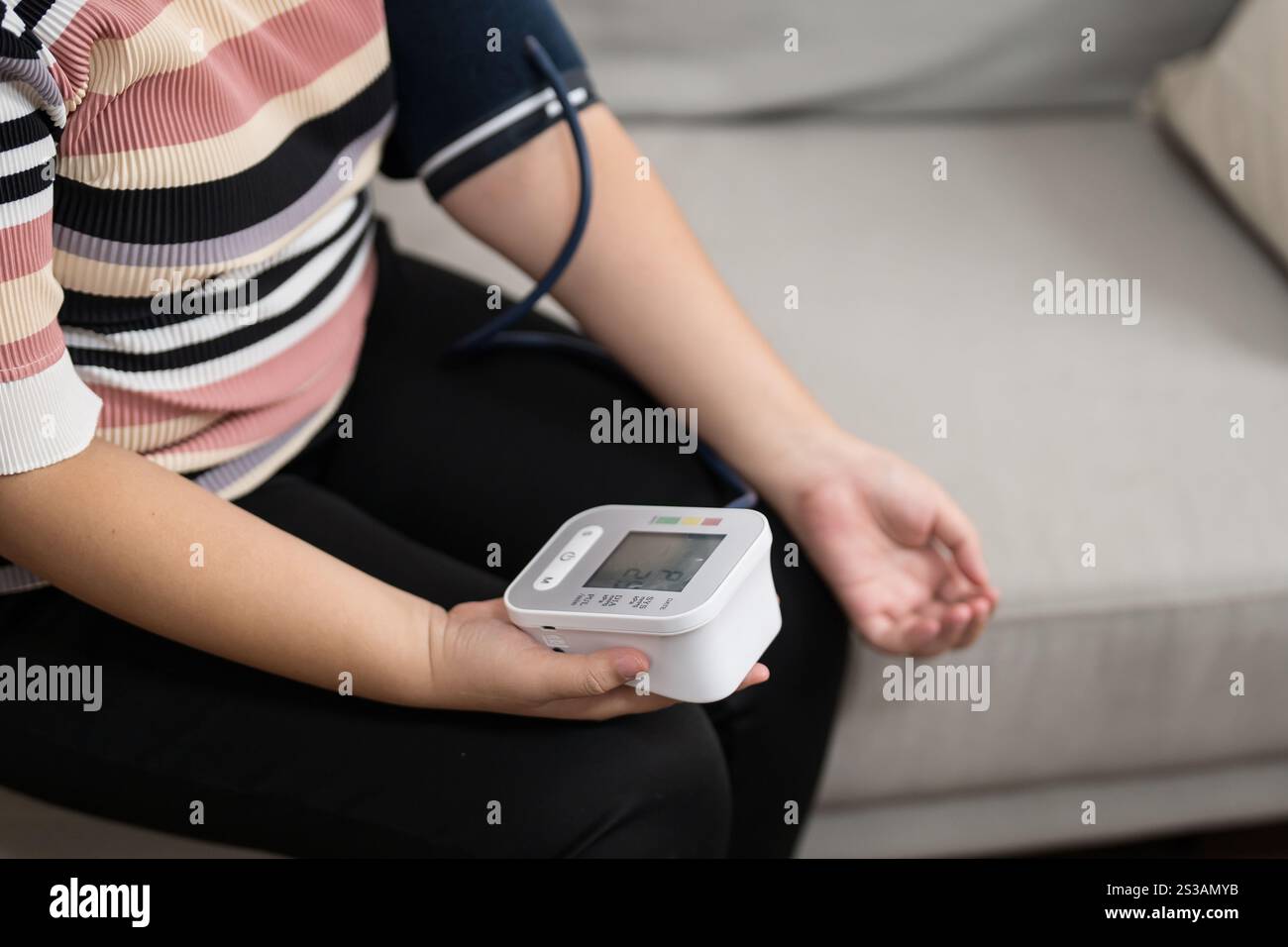 Controllo automatico della pressione sanguigna e della frequenza cardiaca da parte della donna in sovrappeso Plus size. Foto Stock